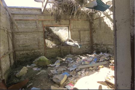 The remaining interior of a destroyed classroom, filled with rubble and debris.