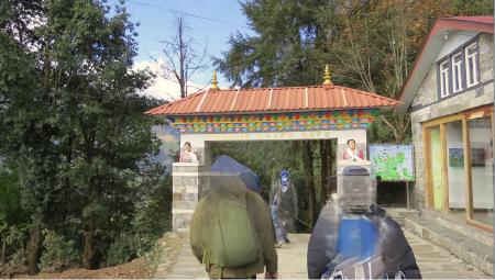 The Pasang Lhamu gate and museum, situated on a walking path heading into a forest area.