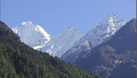 Three snowclad Himalaya peaks lined in a row.