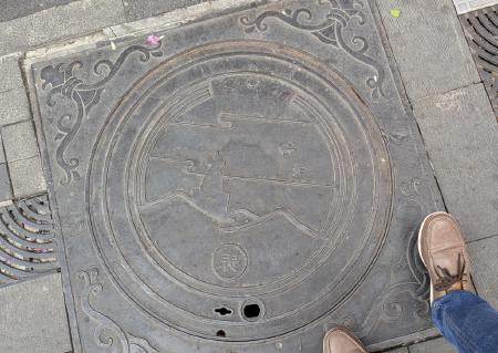 A sewage lid depecting the chaitya.