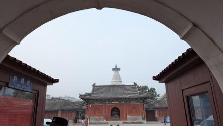 The tip of the chaitya peeking out behind a gate.
