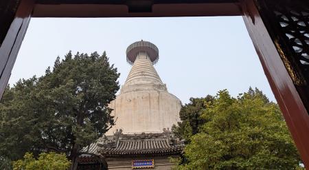 The chaitya, framed by trees and a traditional gate.